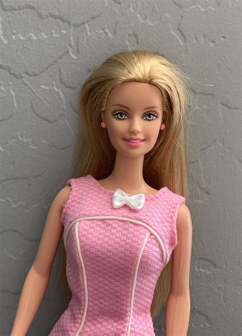 A Barbie Doll Wearing A Pink Dress And White Bow Tie