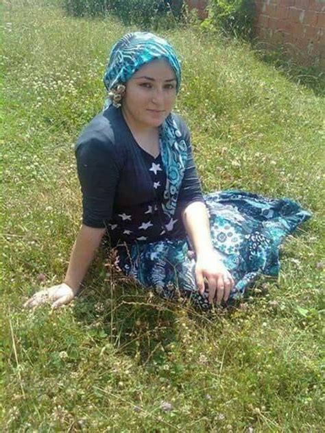A Woman Sitting In The Grass Wearing A Blue Scarf