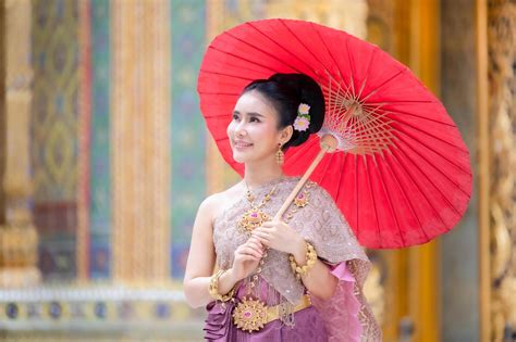 A Beautiful Graceful Thai Woman In Thai Dress Adorned With Valuable Jewelry Holding Red