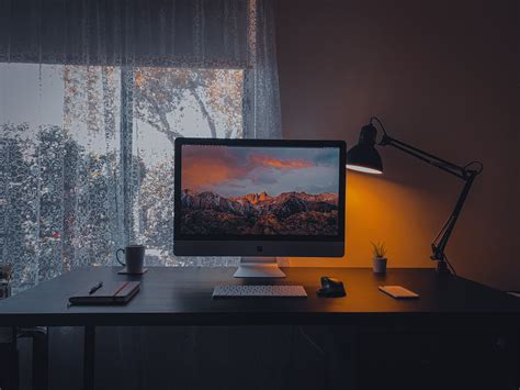 Computer With Mountains On Screen In Dark Room · Free Stock Photo