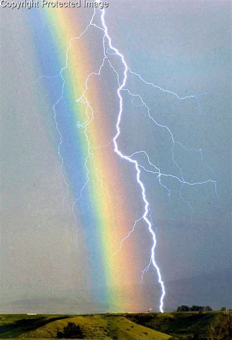 Lightning Bolt Strikes Through A Rainbow Durning A Thunderstorm Over