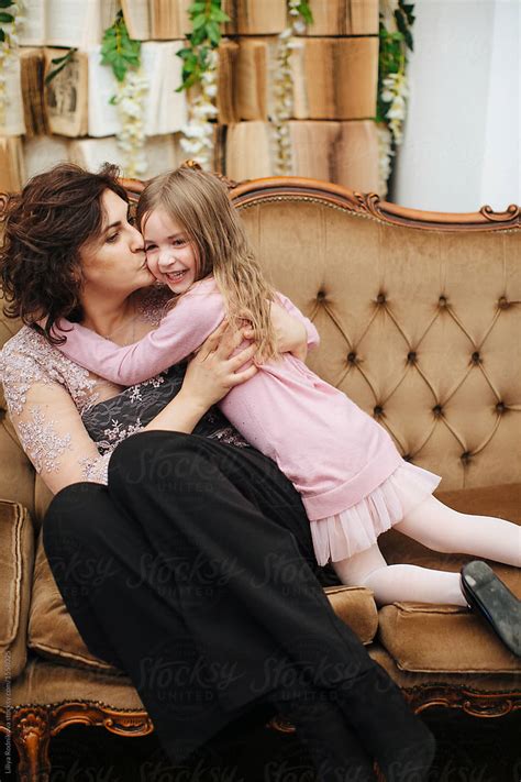 Mother And Daughter Cuddling And Kissing Each Other Indoors By Stocksy Contributor Liliya