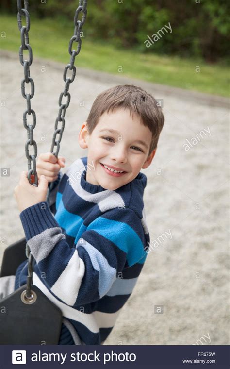 Young Boy On Swing In The Park Stock Photo Alamy