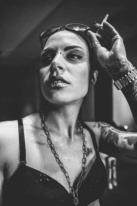 smoke fashionable tattooed girl on the street black and white by stocksy contributor igor