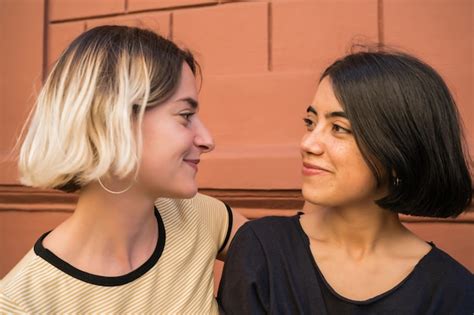 retrato de feliz pareja de lesbianas pasar tiempo juntos y abrazarse en la calle foto premium