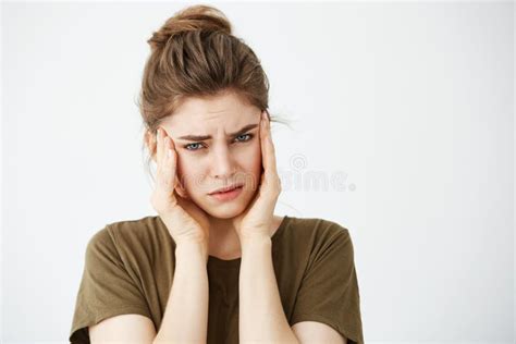 Displeased Nervous Young Girl Holding Head Looking At Camera Over White Background Headache