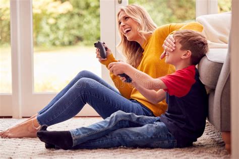 Mother And Son At Home Playing Video Game Together With Woman Cheating