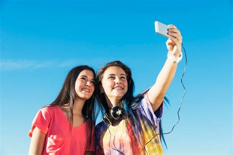 Premium Photo Two Beautiful Teenage Girls Taking Selfie In Park
