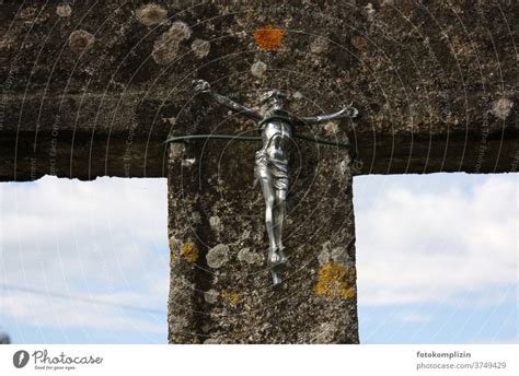 Metal Figure Of Jesus On The Cross Tied To Stone Posts With Wire A