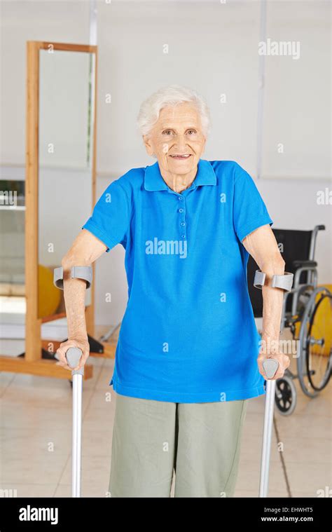 Old Woman With Crutches Smiling In Physiotherapy Room Stock Photo Alamy