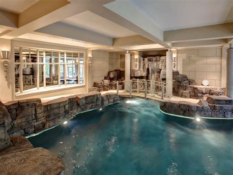 Indoor Pool With Waterfall And Bridge In Luxury Home Pool Houses