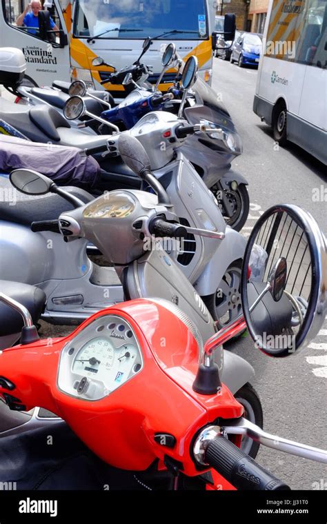 A Red Vespa Scooter Parked In A Row Of Scooters Near Euston Station