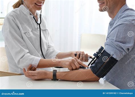 Doctor Checking Patient`s Blood Pressure In Hospital Closeup Stock