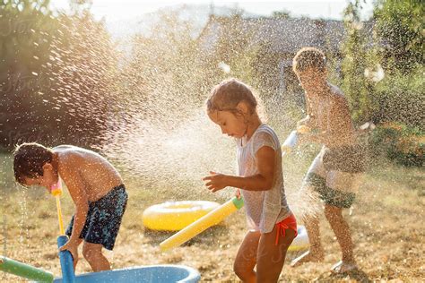 Children Playing With Water Outdoors By Stocksy Contributor Dejan