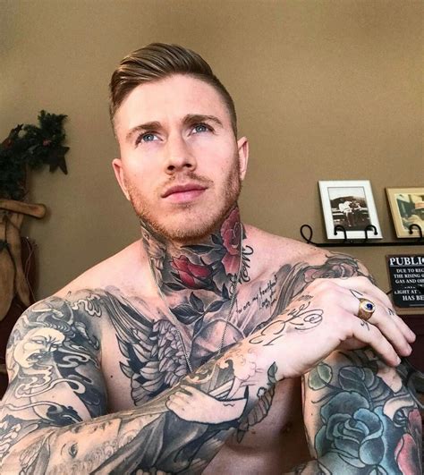 a man with tattoos on his chest and arms