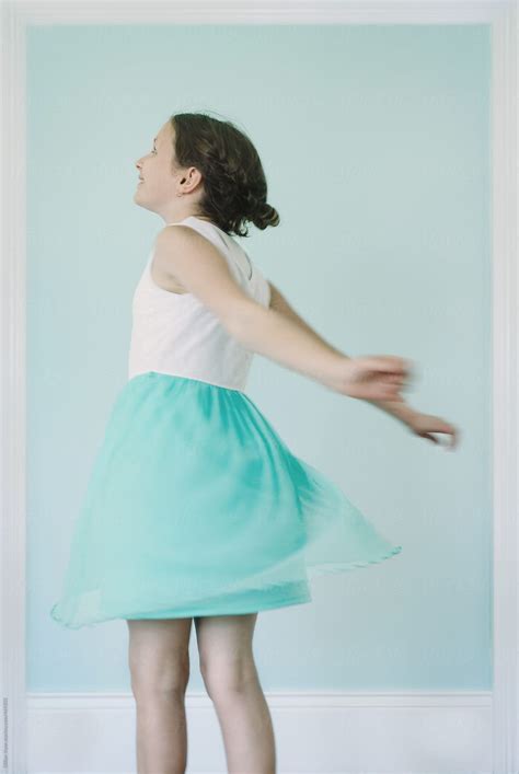 Girl Twirling Is Pretty Blue Dress Against A Blue Wall She Is Framed By Stocksy Contributor