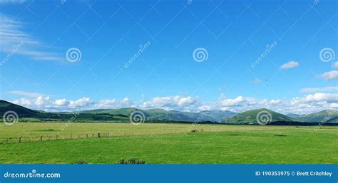 Green Welsh Landscape And Mountains With Blue Sky And White Fluffy