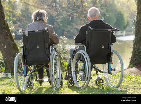Elderly Couple In Wheelchairs Looking At View Stock Photo Alamy