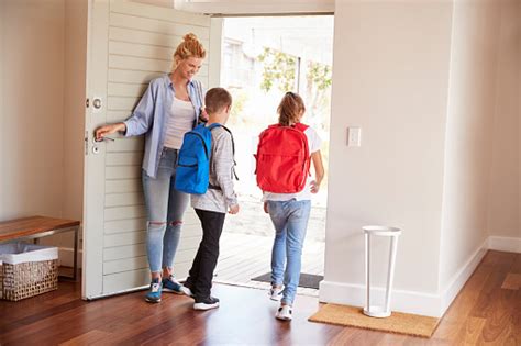 Mother Getting Children Ready To Leave House For School Stock Photo