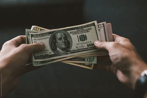 Hands Holding A Stack Of Us Dollar Bills By Stocksy Contributor