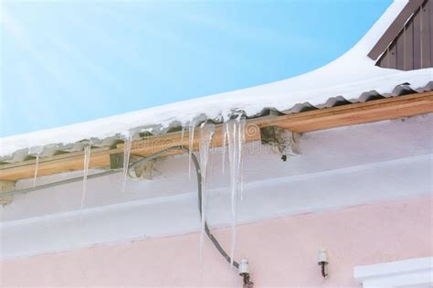 Icicles Hanging On The Roof Under The Bright Sunrays Of Spring Stock