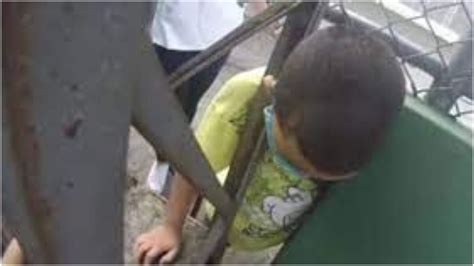 Vídeo Garoto de 7 anos de idade fica preso pela cabeça em grade na