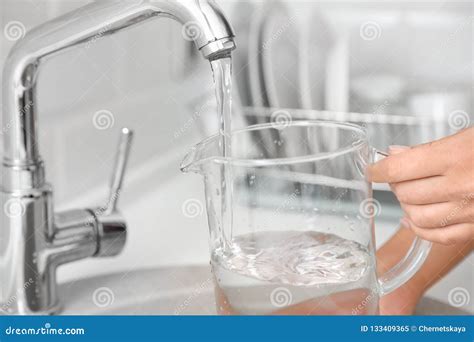 Woman Pouring Water Into Glass Jug In Kitchen Stock Image Image Of