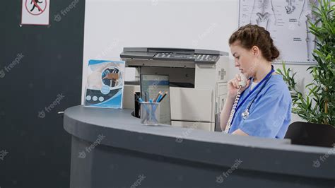 Premium Photo Woman Nurse Answering Landline Phone Call At Reception