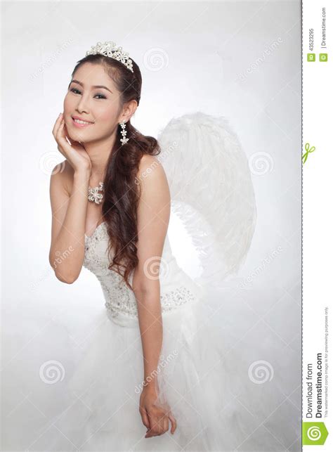 Όμορφη ασιατική γυναίκα πορτρέτου στο άσπρο γαμήλιο φόρεμα με Scepter νεράιδων με τα φτερά