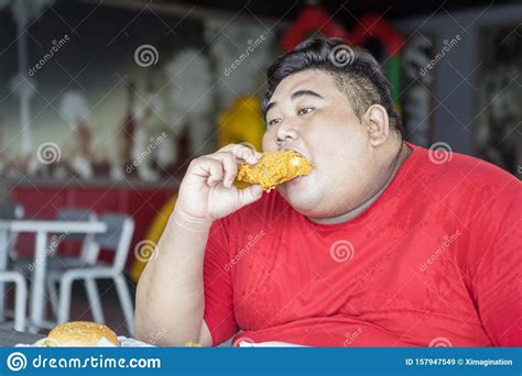 Hombre Obeso Disfruta De Pollo Frito Crujiente Imagen De Archivo