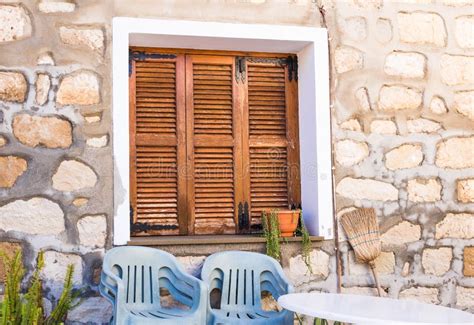 Rustic Brown Wooden Window Shutters With Old Stone Wall Background