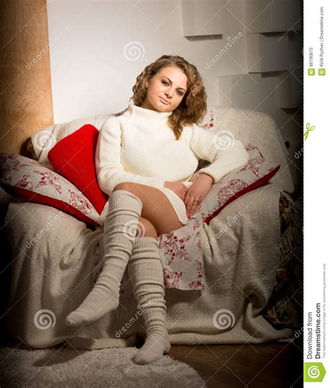 Toned Shot Of Cute Woman In Sweater Sitting In Big Armchair At L Stock