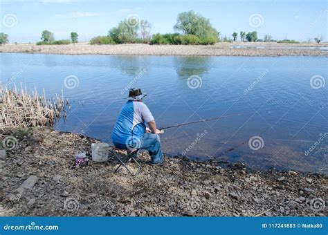 Man Fishing Sitting On A Chair On The River Bank Editorial Stock Photo