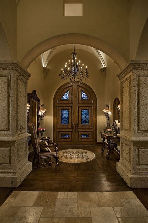 Gorgeous Entry Way With Arched Double Doors That Lead One To The Well