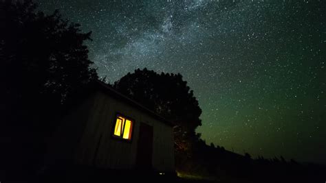 Stars And The Milky Way Over The Night Landscape With Cabin And Tree