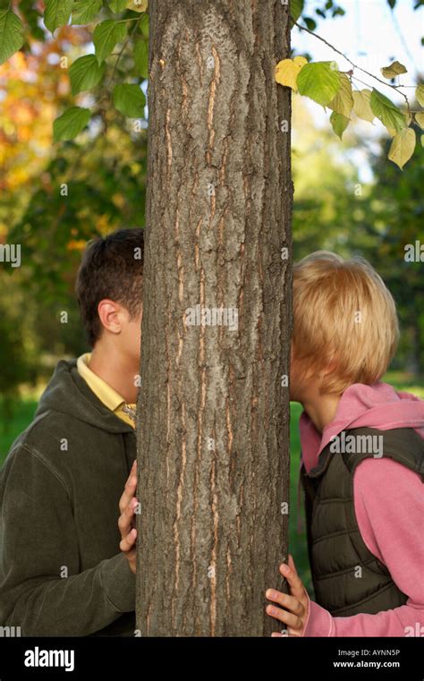 Teenage Couple Kissing Behind A Tree Selective Focus Stock Photo Alamy