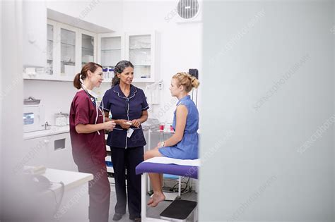 Female Doctor And Nurse Talking To Girl Patient Stock Image F025