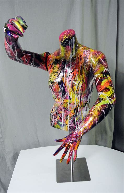 A Colorfully Painted Mannequin Is Posed On A White Surface With His