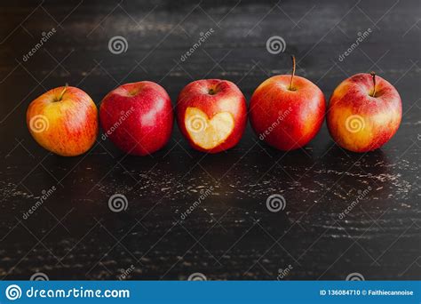 Group Of Red Apples With Different Tones On Dark Wooden Table Stock