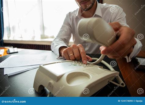Businessman Dialing A Telephone Number In Order To Make A Phone Call