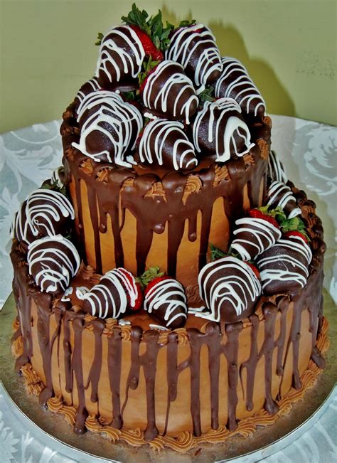 2 tier grooms cake with chocolate dipped strawberries striped in white chocolate chocolate