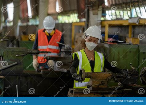 Factory Workers Wear Face Mask Are Working With Machine Stock Photo