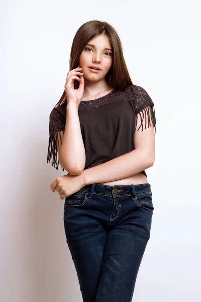 A Beautiful 13 Years Old Girl Dressed In Jeans And T Shirt In Studio On