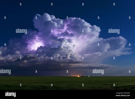A Thunderstorm Cumulonimbus Cloud Is Illuminated By Lightning Near