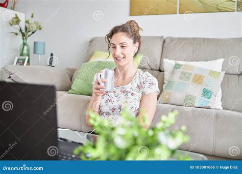 Relaxed Girl Smiling And Looking At A Laptop In Her Living Room Stock