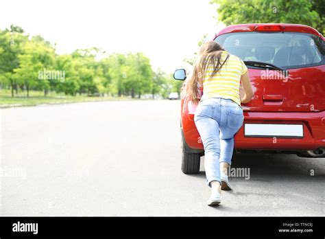 Woman Pushing Red Car Stock Photo Alamy