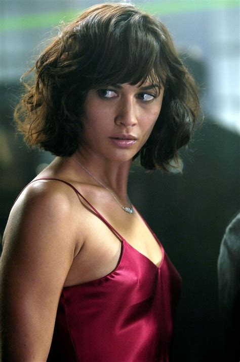 A Woman In A Red Dress Looking At The Camera With An Intense Look On