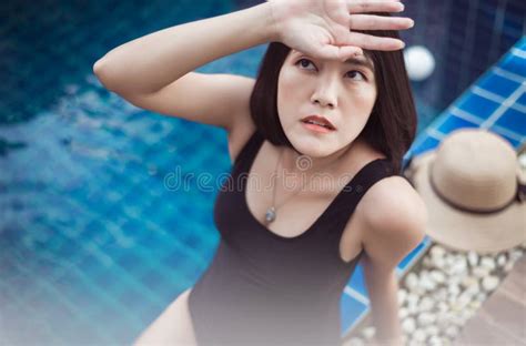 beautiful and asian woman wearing bikini sitting on swimming pool summer vacation concept stock