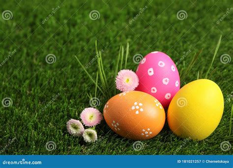 Colorful Easter Eggs And Daisy Flowers On Grass Space For Text Stock