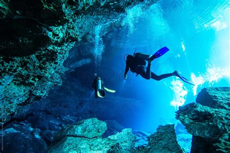 Scuba Divers Exploring An Underwater Cave In A Cenote In Yucatán